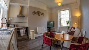 A compact living space with a kitchen, dining area, and seating. - Church Lane Apartments (Boston)
