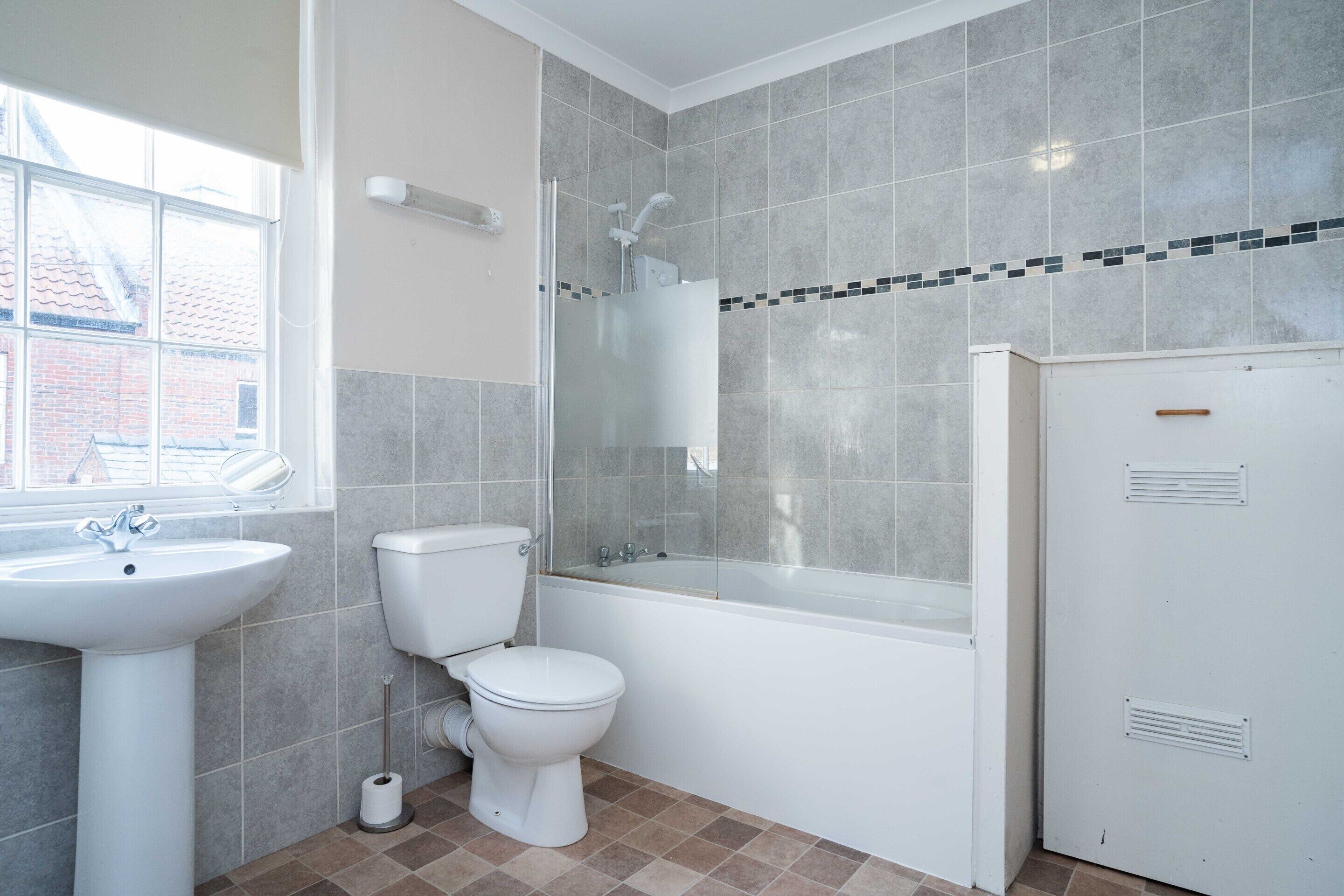 Un baño con lavamanos, inodoro, bañera y ventana.