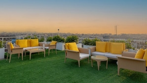 A rooftop terrace with outdoor furniture and a city view. - Bloom Hub WEH Andheri (Mumbai)
