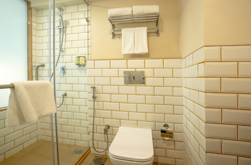 A bathroom with a shower, toilet, and towel rack.