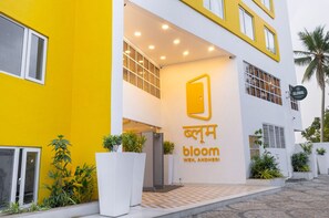 A modern building with a yellow facade, a large entrance, and a sign reading "bloom weh, andheri". - Bloom Hub WEH Andheri (Mumbai)