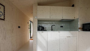 A modern kitchen with wooden cabinetry and a tiled backsplash.