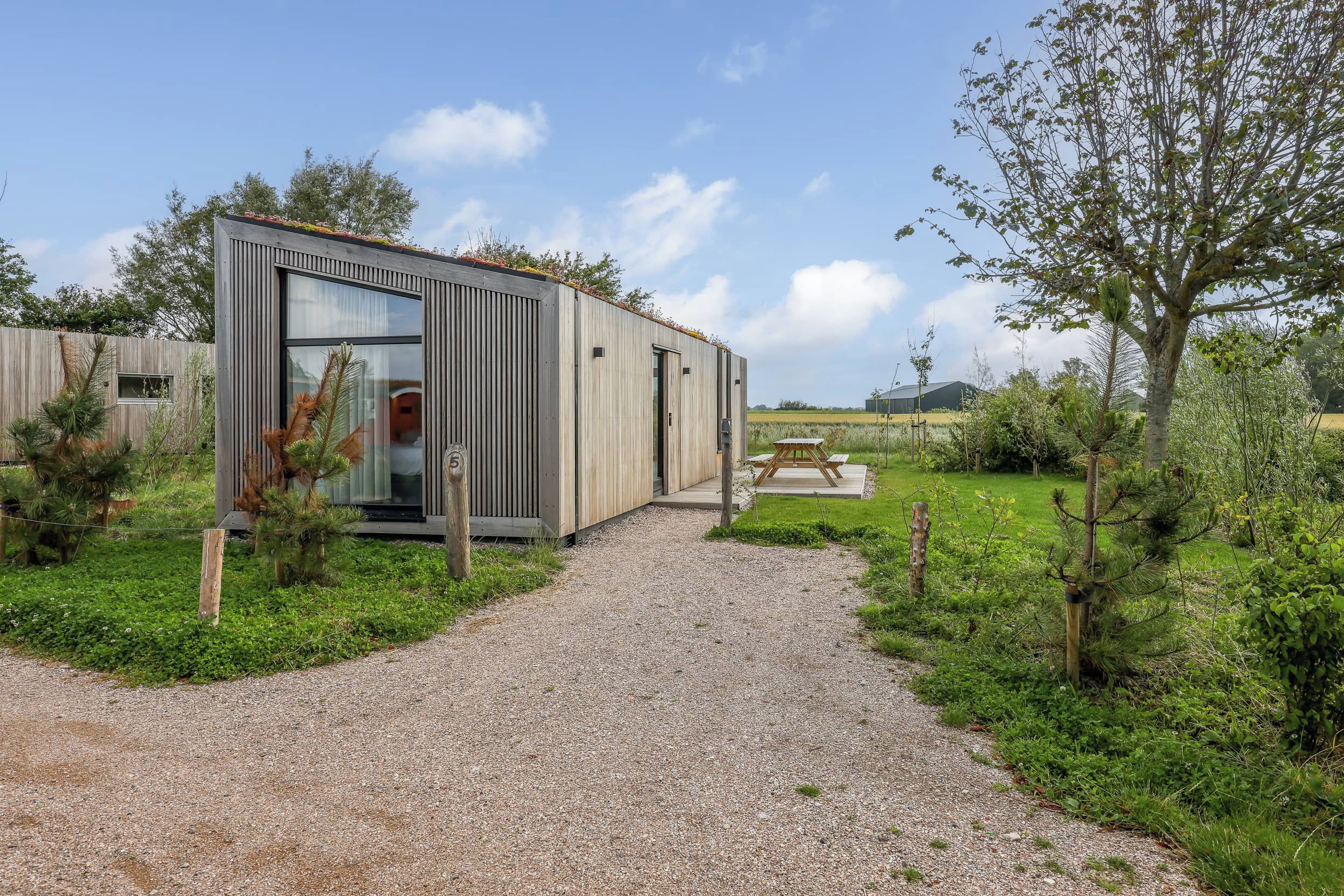 A modern, single-story building with a gravel path leading to the entrance.