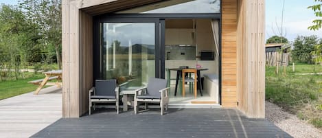 Una estructura moderna de madera con un cristal que da a un espacio interior.