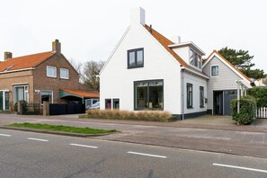 A row of residential houses with a modern design, featuring a mix of brick and white facades, and a central house with a prominent gable roof. - Holiday home near the sea in Domburg | Schelpweg 16A (Domburg)