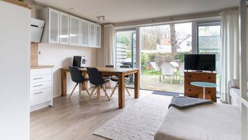 Een moderne slaapkamer met een bed, een televisie en een bureau met een computer.