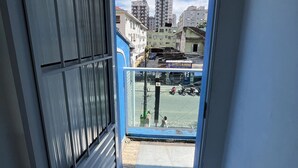 A view from a balcony with a cityscape in the background, including tall buildings and parked motorcycles. - Pousada Aloha Santos (Santos)