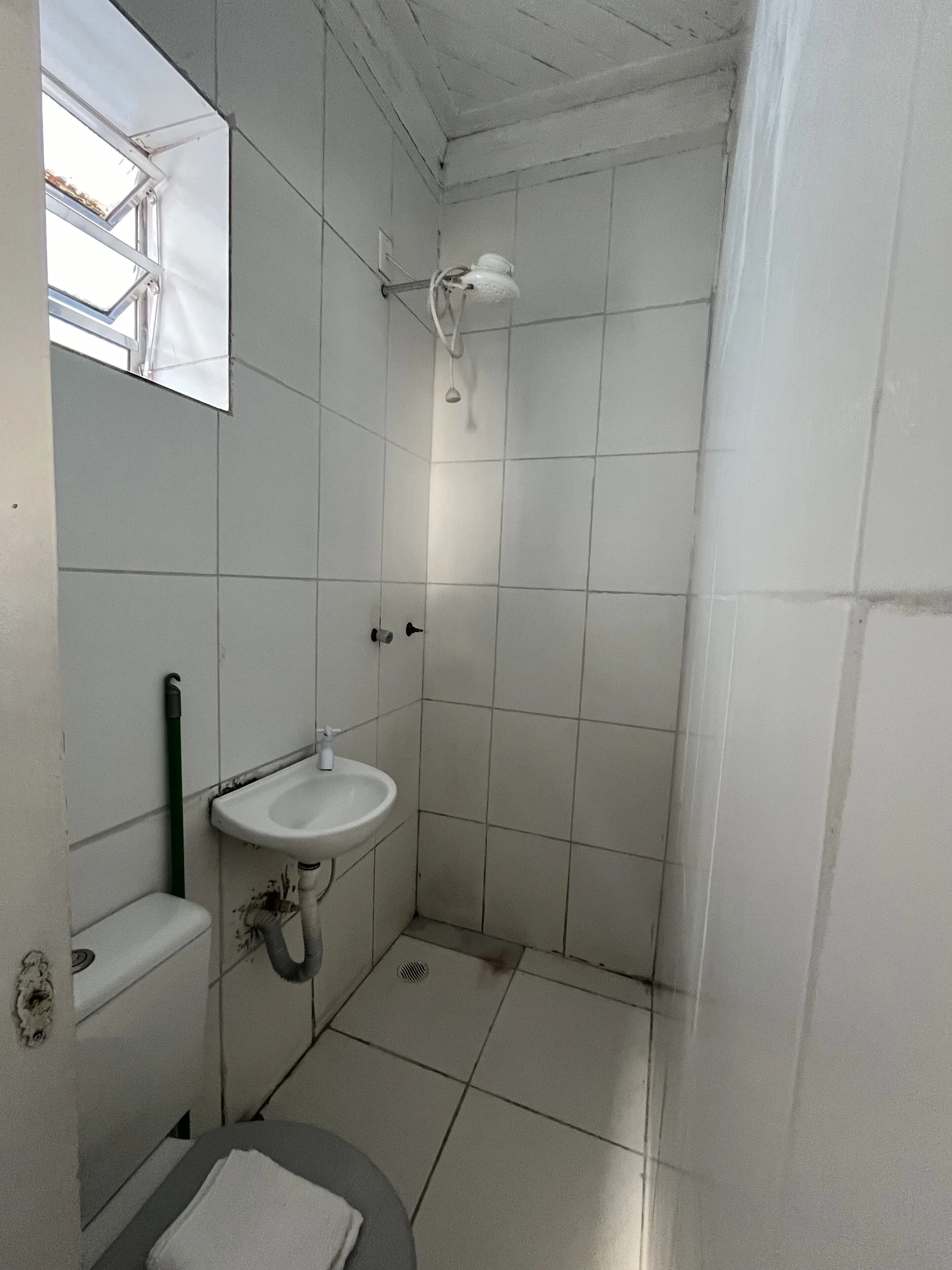 Un baño pequeño con azulejos, un lavabo, un espejo y una ducha.