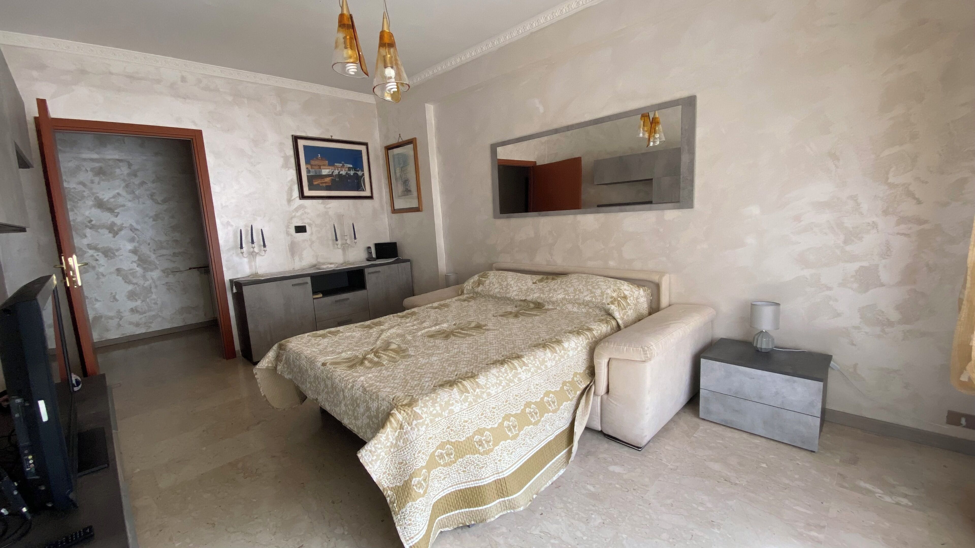 A bedroom with a bed, bedside table, and a dresser.