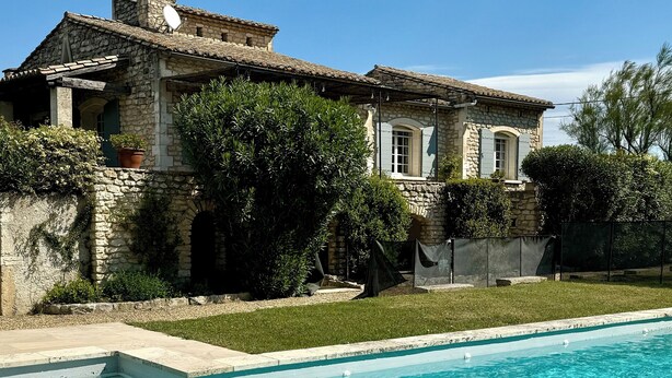 Ein Haus aus Stein mit einem Swimmingpool.