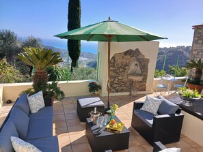 A terrace with outdoor furniture, a stone wall, and a view of the landscape. - Localita Castiglione 3 Anwesen in Einer Liebevoll Renovierten Ölmühle (Camporosso)