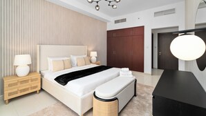 A modern bedroom with a large bed, bedside tables, a wardrobe, and a desk. - Nasma Holiday Homes - Bab Al Bahr Residences (Ras Al Khaimah)