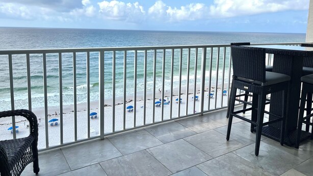 Un balcón con vista al océano y la playa.