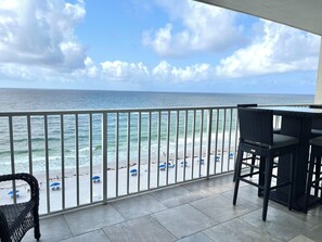 Ein Balkon mit Blick auf das Meer und den Strand.