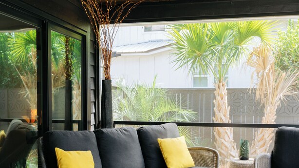 A modern outdoor living area with a grey sofa, yellow cushions, wicker chairs, and a round coffee table. - Grayt Balls of Fire 4 bed, 4 1/2 bath, private pool  Grayton Beach (Santa Rosa Beach)