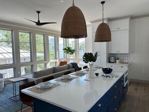A modern kitchen with a large island, pendant lights, and a view of the outdoors. - 127 Banfill Street 2 bed 2 bath private pool, dock on Grayton Lake (Santa Rosa Beach)