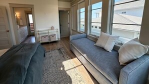 Een moderne woonkamer met een groot raam, een bank en een kleine tafel.