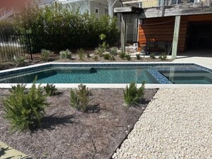 A rectangular swimming pool with a clear blue water surface, surrounded by a gravel area and small green shrubs. - 127 Banfill Street 2 bed 2 bath private pool, dock on Grayton Lake (Santa Rosa Beach)