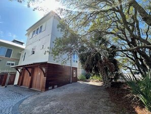A two-story building with a garage and a paved driveway. - 127 Banfill Street 2 bed 2 bath private pool, dock on Grayton Lake (Santa Rosa Beach)