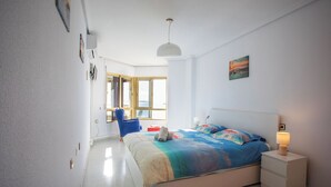 A bedroom with a bed, bedside table, and a chair. - First line apartment with sea view (Lo Pagán)