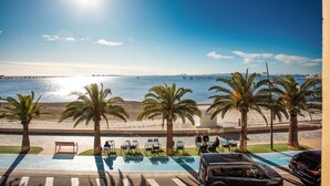 A beachside view with palm trees, a parking area, and a view of the sea. - First line apartment with sea view (Lo Pagán)