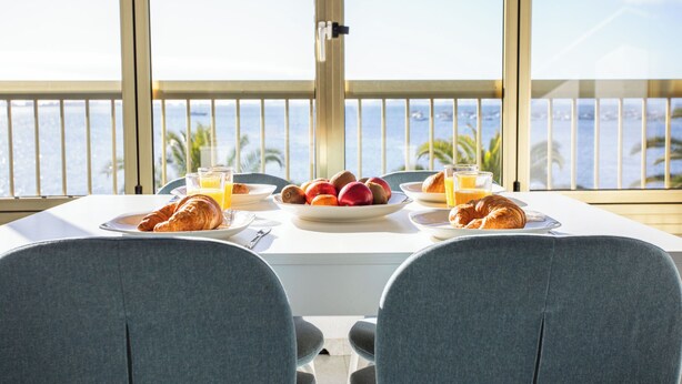 A dining table with breakfast items and a view of the sea. - First line apartment with sea view (Lo Pagán)