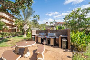 An outdoor patio with a barbecue grill and a table.