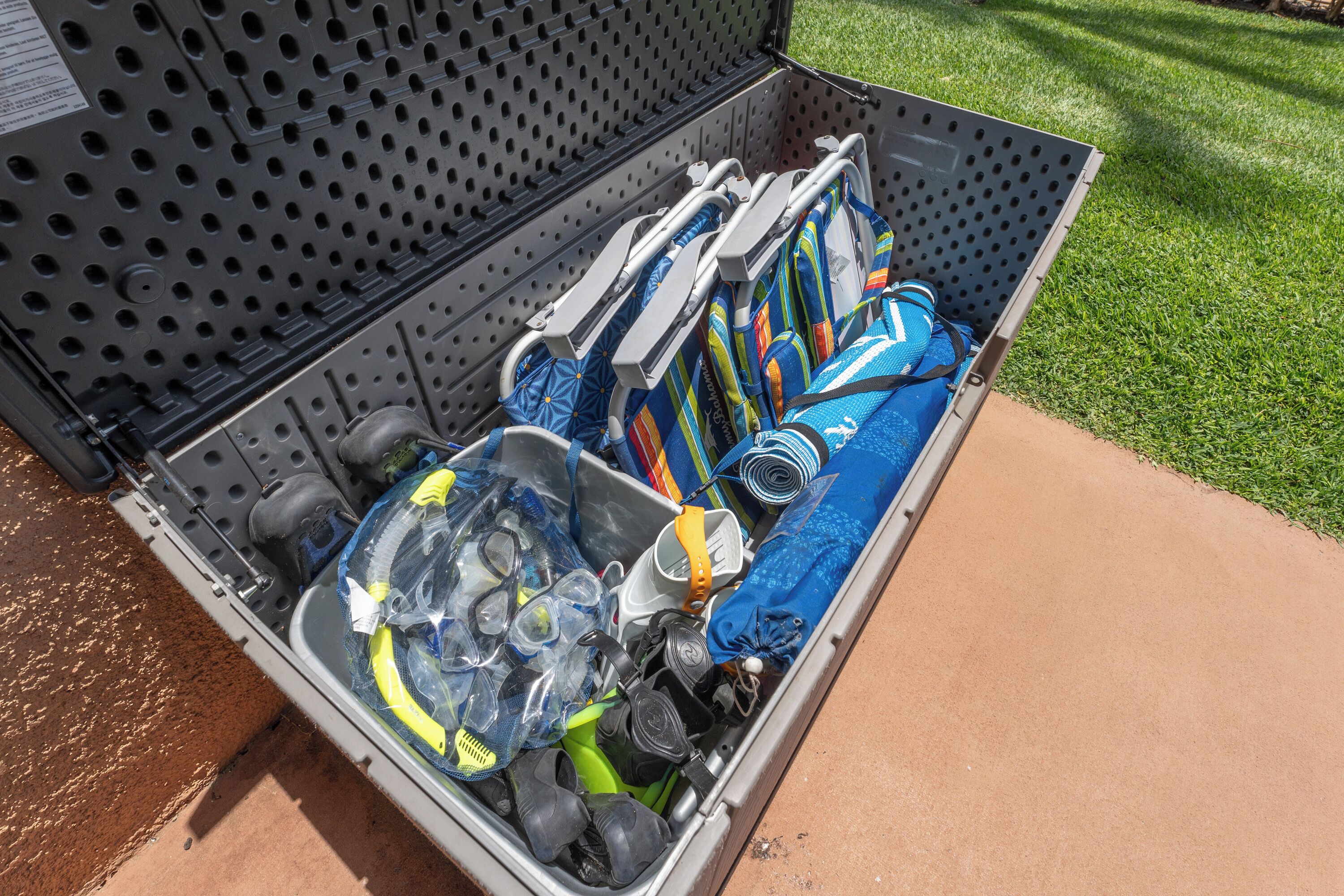 A storage unit with a perforated metal exterior, containing various items including a blue umbrella, a green water bottle, and a pair of sunglasses.