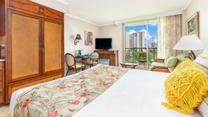 Une chambre d’hôtel avec un grand lit, un bureau, une télévision et une vue sur la ville.