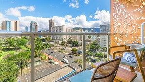 Un balcon avec vue sur la ville, un coin repas avec une table et des chaises, et un mur décoratif.