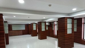 A spacious, modern lobby with a polished tile floor, wooden paneling, and glass partitions. - Hotel Autumn Crocus (Guwahati)