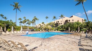 A pool area with lounge chairs and palm trees. - Vacation Retreat at Kamaole Sands, Steps from Kamaole Beach III! (Kihei)