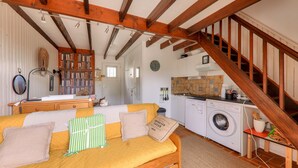 Um quarto acolhedor com uma cama, máquina de lavar e escada.
