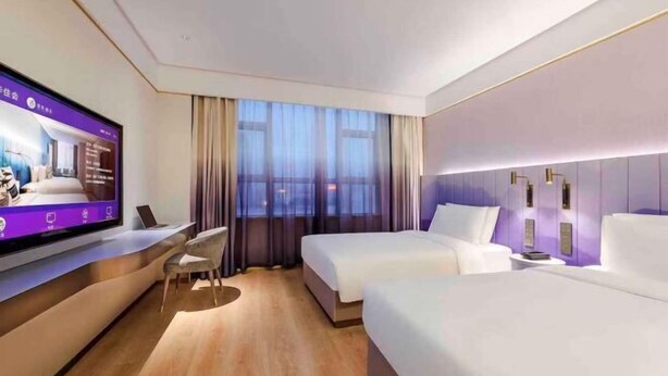 A modern hotel room with a large flat-screen TV, two beds, a desk, and a chair. - Yishang Hotel (Shanghai Hongqiao International Exhibition Center Jiangqiao Wanda Branch) (Shanghai)