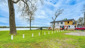 A house under construction near a lake with a 'Please keep off' sign, a tree, and a red car. - Kayak & Fish: 1 Block to Lakeside Park & Ramp! (Dowagiac)
