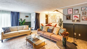 A living room with a beige sofa, a glass coffee table, and a floor lamp. - Vibrant Tacoma Retreat, Near Point Defiance Park! (Tacoma)