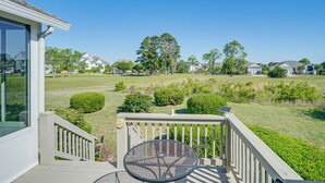 A deck with a metal table and a view of a golf course. - Wilmington Home w/ Sunroom & Private Deck! (Wilmington)