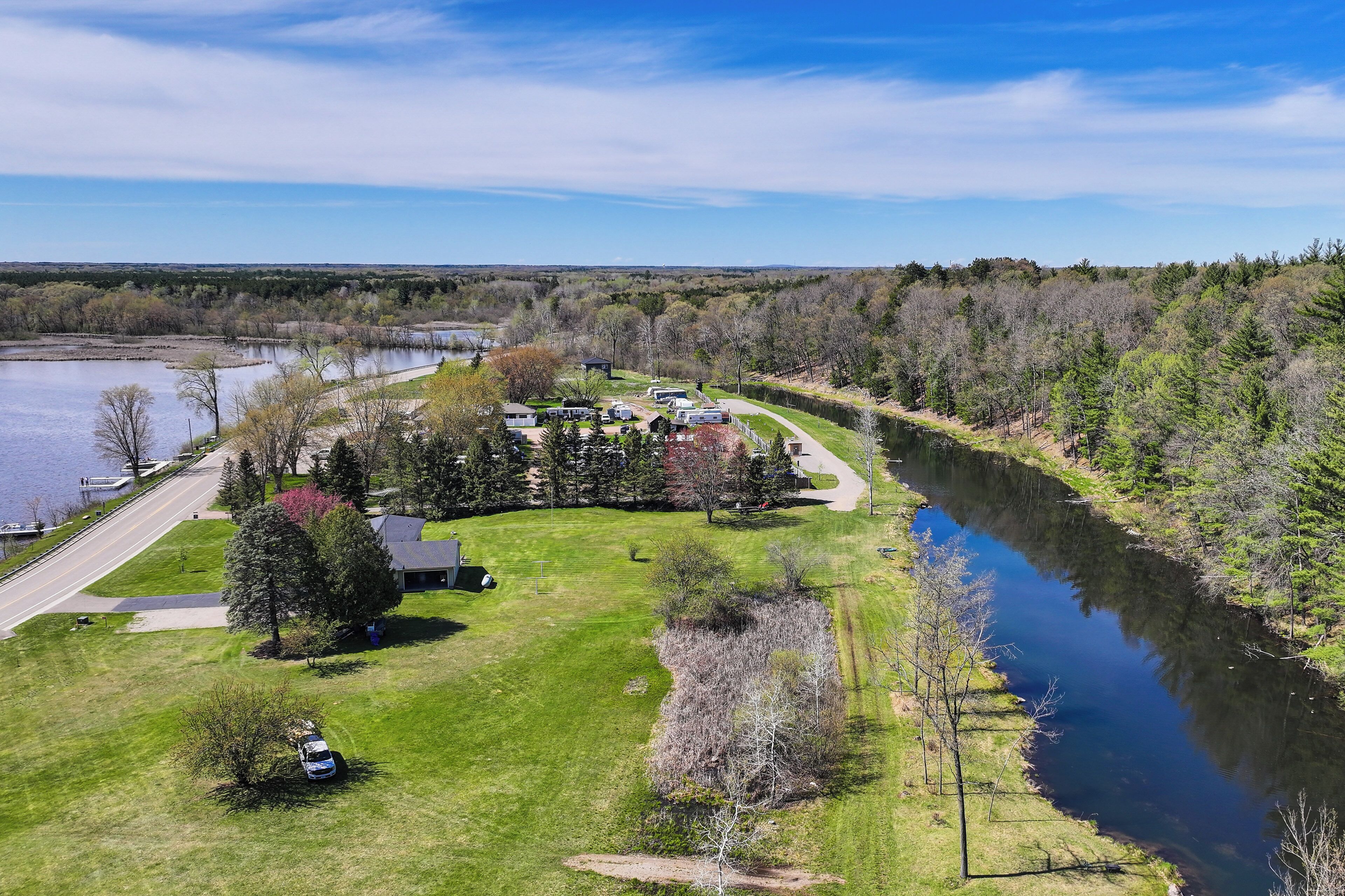 An aerial view of a residential area with houses, a river, and a road.