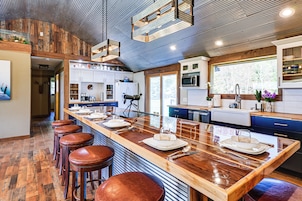 Una cocina moderna con una isla grande, taburetes de bar y vistas al exterior.