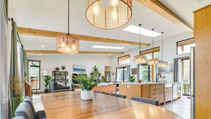Une cuisine spacieuse, dotée de meubles en bois, d’un grand îlot central et d’appareils électroménagers modernes.