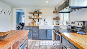 A modern kitchen with a wooden countertop, a built-in oven, and a stainless steel range hood. - Lovely Ludlow Farmhouse ~ 1 Mi to Town & Slopes! (Ludlow)