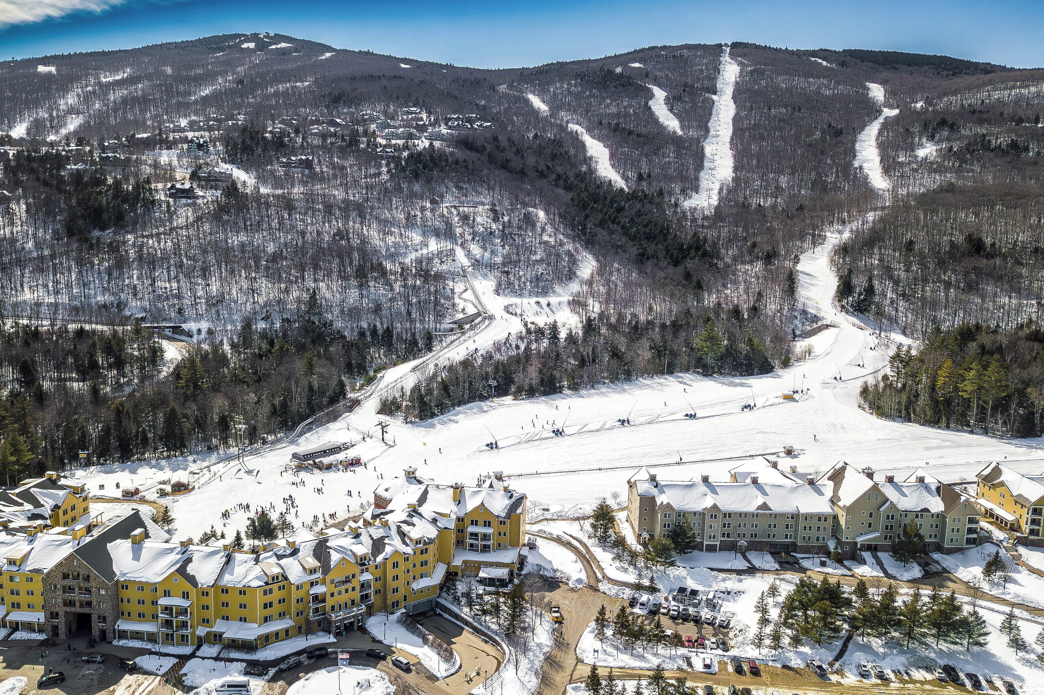 Un gran complejo turístico con varias construcciones, una pista de esquí y un paisaje cubierto de nieve.