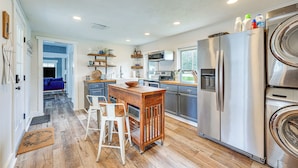 A modern kitchen with a central island, stainless steel appliances, and a view to the backyard. - Lovely Ludlow Farmhouse ~ 1 Mi to Town & Slopes! (Ludlow)