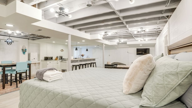 Un dormitorio amplio con una cama grande, una kitchenette y un comedor.
