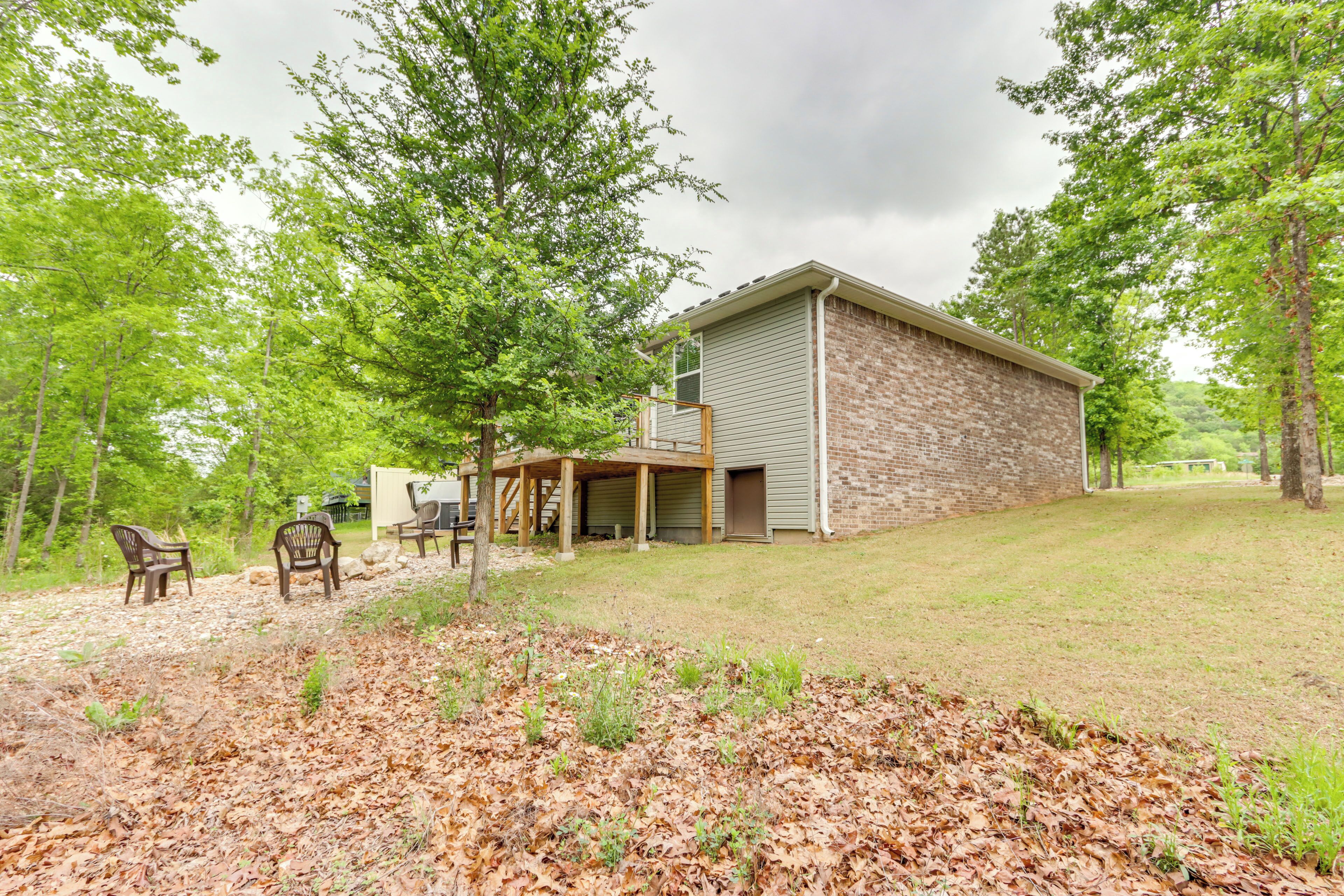 A two-story brick house with a covered porch and a small deck.
