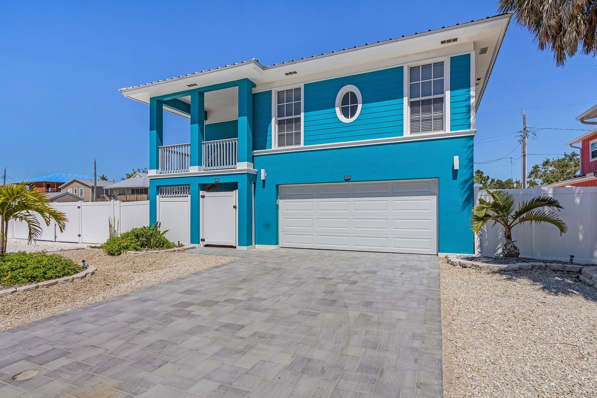 A two-story house with a garage, a balcony, and a driveway.