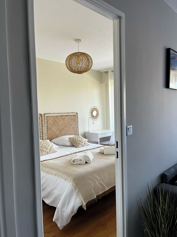 A bedroom with a bed, bedside table, lamp, and a hanging light fixture. - Antibes - Appartement 2 Pièces - 4 Personnes - Climatisation - Proche Centre (Antibes)