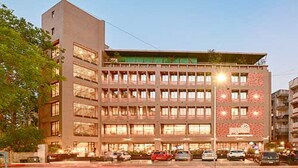 A multi-story hotel with a modern design, featuring a prominent entrance and a series of windows on the facade. - Hotel Page One (Ahmedabad)