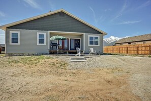 A single-story house with a covered patio area, a gravel driveway, and a wooden fence. - Mount Oxford Home w/Starlink & outdoor patio (Buena Vista)