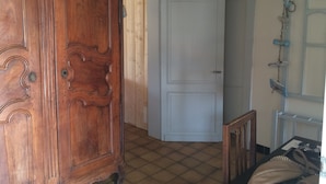 Ein Zimmer mit einem Holfschrank, einer weißen Tür und einem Fliesenboden.